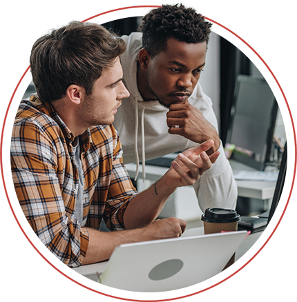 2 men chatting around a laptop